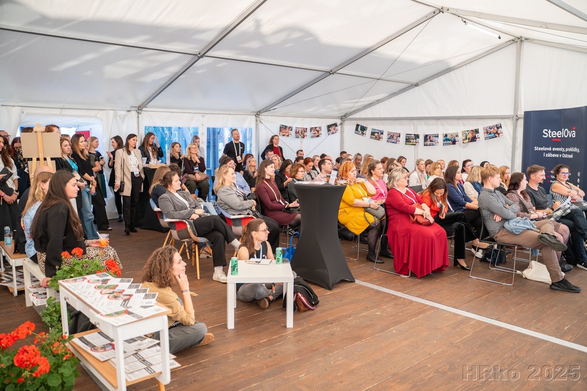 Networking hostů a partnerů ve společenské zóně firemní akce